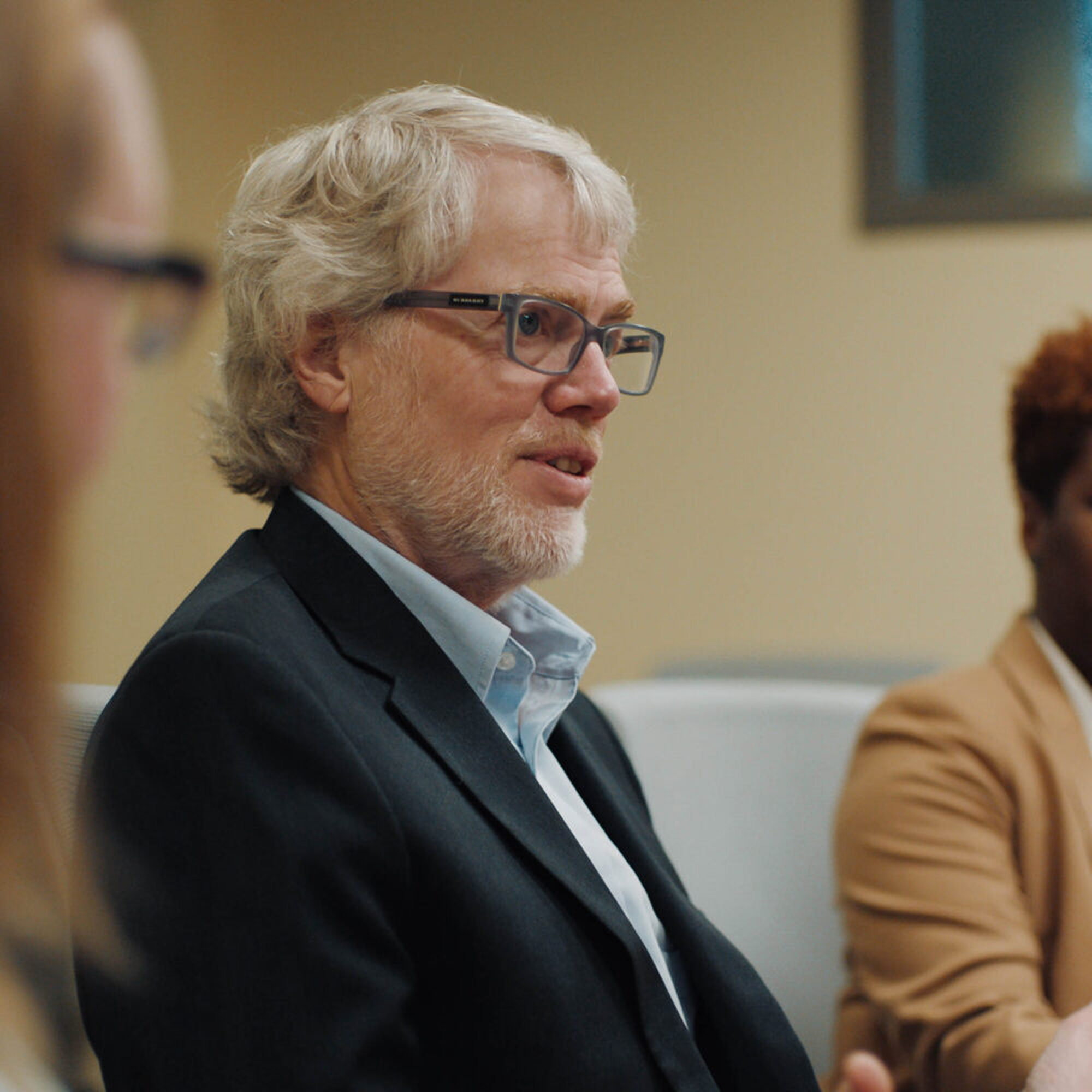 Three people in conversation around a conference table.