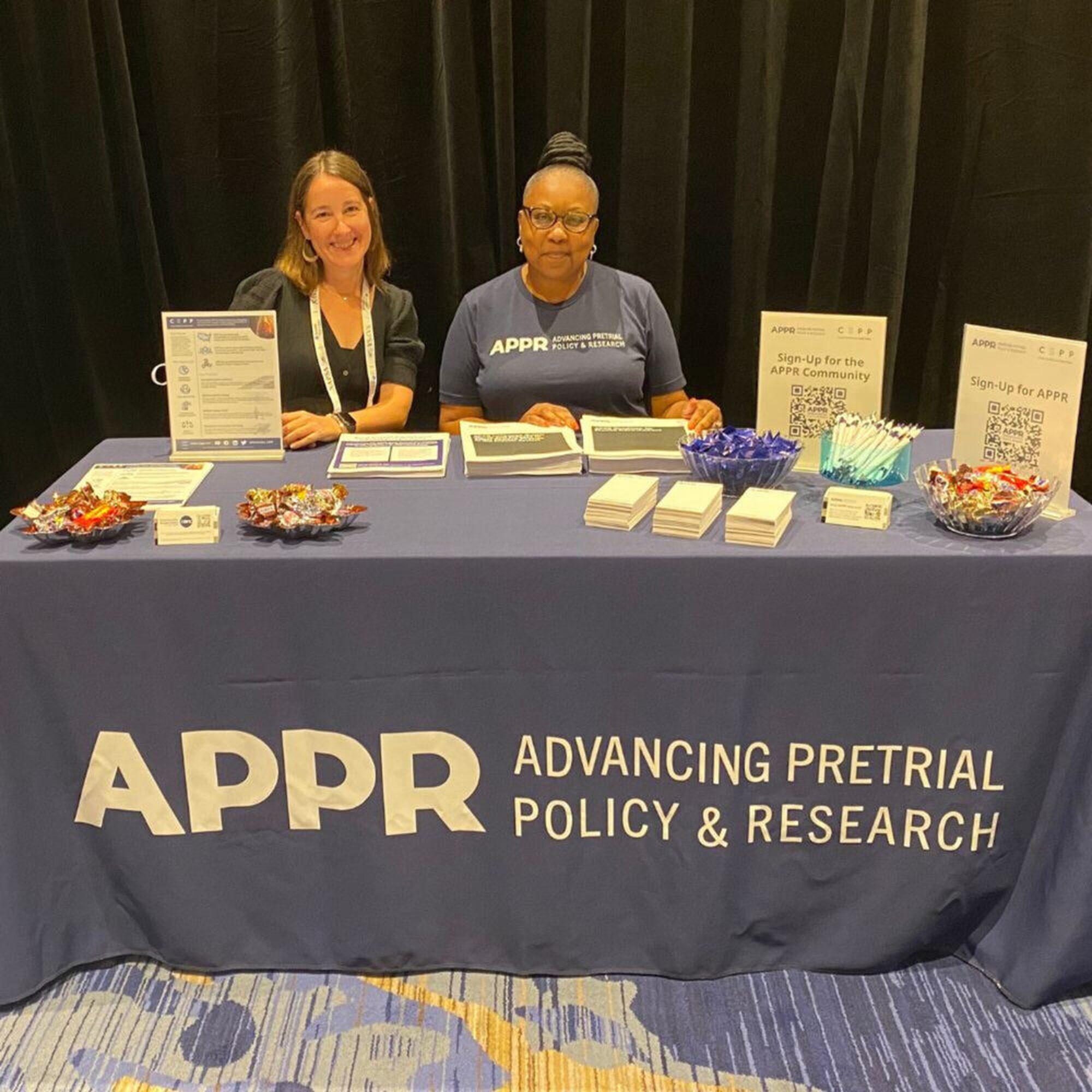 APPR staff at a table with signs for Advancing Pretrial Policy and Research.