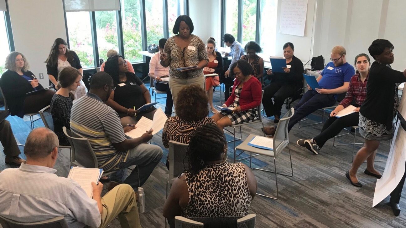 A woman leading a small community meeting.