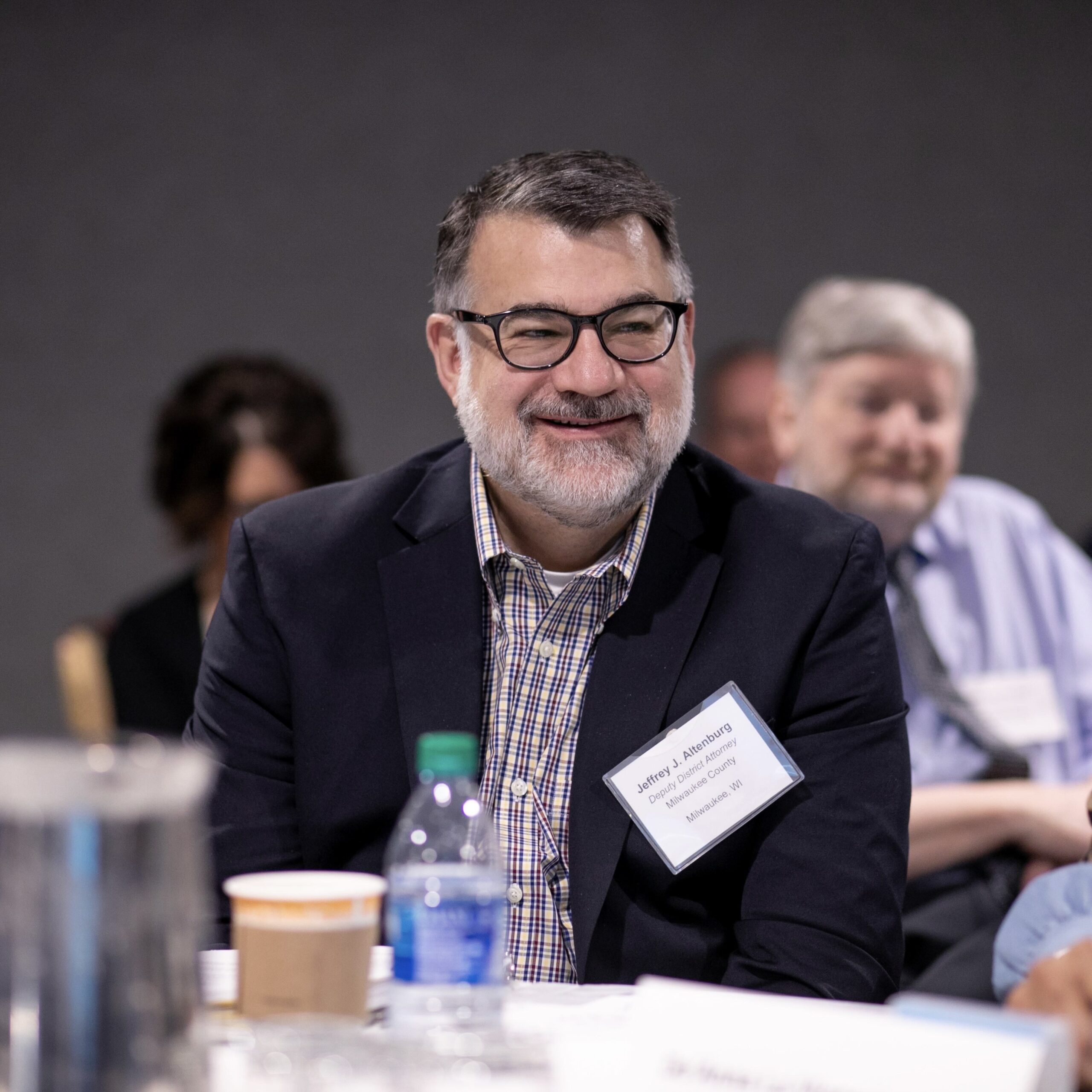 A man smiles in a group of people